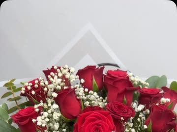 Hediye çantasında kırmızı güller ve beyaz çiçeklerden hazırlanmış buket
